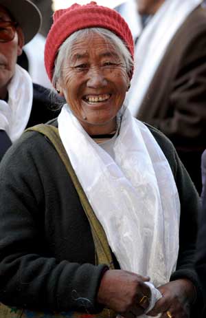 Sonam, a retiree of Tibet passenger transport station, smiles after receiving her 800-yuan-worth shopping coupon from the authority in Lhasa, capital of southwest China's Tibet Autonomous Region, on January 23, 2009.