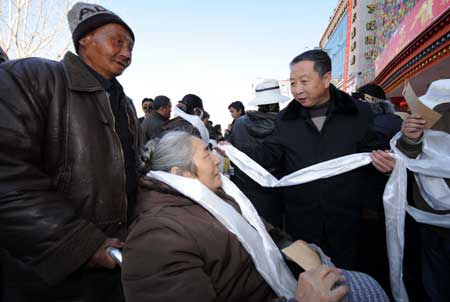 A government official dedicates a piece of Hada to needy citizens while distributing the shopping coupons in Lhasa, capital of southwest China's Tibet Autonomous Region, on January 23, 2009.