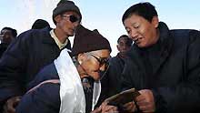 A government official distributes the shopping coupons in Lhasa, capital of southwest China's Tibet Autonomous Region, on January 23, 2009.