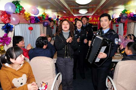 Railway policemen perform for travelers on a train on January 23, 2009. An evening party was held on board to celebrate the upcoming Spring Festival with travelers.