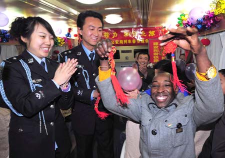 A foreign traveler receives traditional Chinese knots in an evening party on a train on January 23, 2009. 