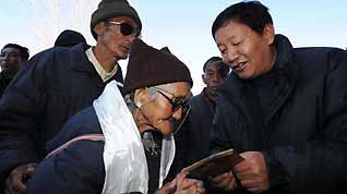 A government official distributes the shopping coupons in Lhasa, capital of southwest China's Tibet Autonomous Region, on January 23, 2009. With the Spring Festival drawing near, the government of Tibet handed out shopping coupons each worth 800 yuan to 37,026 needy citizens receiving the minimum living allowances and 31,375 retirees of state-run firms on Friday.