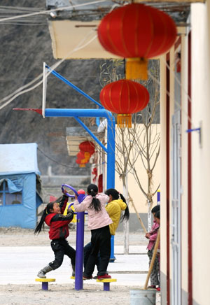 Kids play outside newly-built houses at Songba village in Wenxian County of Longnan City, northwest China's Gansu Province, on January 23, 2009. A total of 66 quake-affected families at Songba village moved into the 216 new houses before the Chinese Lunar New Year.