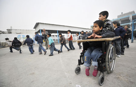 Shakir Auda, sitting in a wheelchair, looks at his schoolmates in the Beit Loliya Boys Elementary School in Gaza City on January 24, 2009. Some 200,000 Gaza children returned to school for the first time since Israel&apos;s offensive.