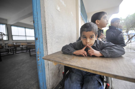 Shakir Auda, sitting in a wheelchair,takes a rest during a break in the Beit Loliya Boys Elementary School in Gaza City on January 24, 2009. Some 200,000 Gaza children returned to school for the first time since Israel&apos;s offensive.