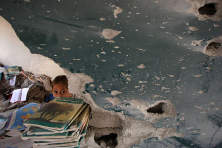 A girl searches for useful books in a destroyed building of Khalil AL-Nubani School in Gaza City on January 24, 2009. Some 200,000 Gaza children returned to school for the first time since Israel&apos;s offensive.