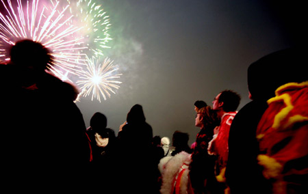 People watch the fireworks greeting the Chinese Lunar New Year outside the railway station of Berlin, capital of Germany, on January 23, 2009.