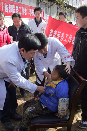 An expert from Beijing examines a boy in Beichuan County in southwest China's Sichuan Province, on January 24, 2009. About 40 medical personnels from Beijing returned to quake zone to offer medical treatment free of charge for people there.