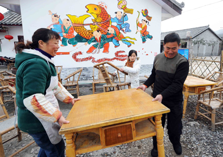 Xian Tianquan (L) and his family carry table in preparation of reopen his restaurant during Spring Festival in Penghua Village of Zundao Town in Mianzhu City, southwest China's Sichuan Province, on January 24, 2009.