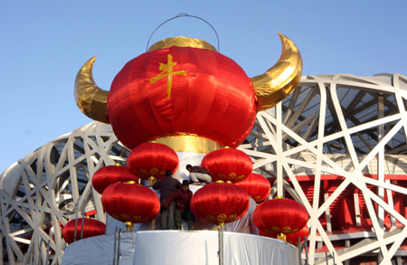 Chinese workers positioin a giant festive lantern carrying a Chinese character of 'ox' to welcome the traditional New Year of cattle in front of the Olympic National Stadium, or the Bird's Nest, in Beijing, on January 24, 2009.