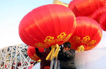 Chinese workers positioin a giant festive lantern carrying a Chinese character of 'ox' to welcome the traditional New Year of cattle in front of the Olympic National Stadium, or the Bird's Nest, in Beijing, on January 24, 2009.