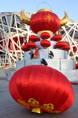 Chinese workers positioin a giant festive lantern carrying a Chinese character of 'ox' to welcome the traditional New Year of cattle in front of the Olympic National Stadium, or the Bird's Nest, in Beijing, on January 24, 2009.