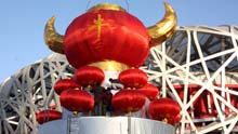 Chinese workers positioin a giant festive lantern carrying a Chinese character of 'ox' to welcome the traditional New Year of cattle in front of the Olympic National Stadium, or the Bird's Nest, in Beijing, on January 24, 2009.