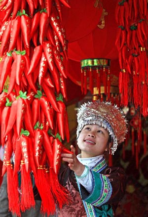 A Miao minority woman picks up festival decorations for the upcoming Chinese Lunar New Year of Ox in Rongshui County, south China's Guangxi Zhuang Autonomous Region, on Saturday, on January 24, 2009.