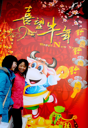 Two women walk past a mall with festive decoration in Zhengzhou, capital of north China's Henan Province, on January 25, 2009.