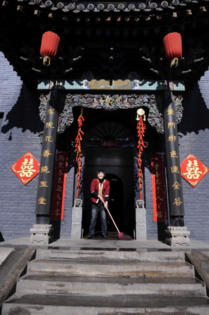 A girl sweeps the yard with festive decoration in Pingyao, a city of north China's Shanxi Province, on January 25, 2009.