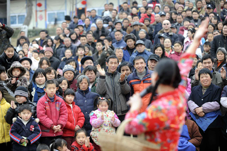 Locals gather to watch a show celebrating the Spring Festival in Pengzhou, a quake-hit city of southwest China's Sichuan Province, on January 25, 2009. Quake zone residents in west China had made their own ways to welcome the Spring Festival, or the Chinese Lunar New Year.