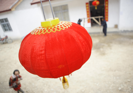 Villagers hang on red lanterns celebrating the Spring Festival in Lueyang, a county badly hit by the May 12, 2008 earthquake in northwest China's Shaanxi Province, on January 25, 2009.