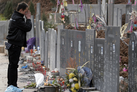 A young Chinese mourns his deceased classmate, a victim of the May 12, 2008 earthquake, at a graveyard in Shifang, southwest China's Sichuan Province, on January 24, 2009, ahead of the Chinese Lunar New Year.