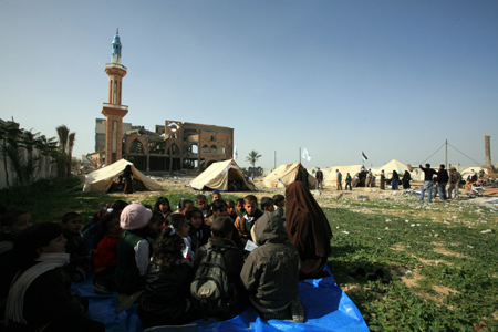 Palestinian pupils attend a class outside their destroyed school in Rafah, southern Gaza Strip, on January 25, 2009.