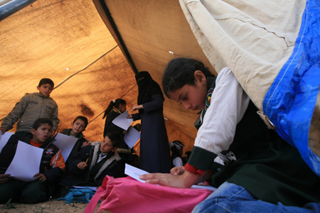 Palestinian pupils attend a class outside their destroyed school in Rafah, southern Gaza Strip, on January 25, 2009.