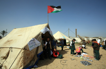 Palestinian pupils attend a class outside their destroyed school in Rafah, southern Gaza Strip, on January 25, 2009.