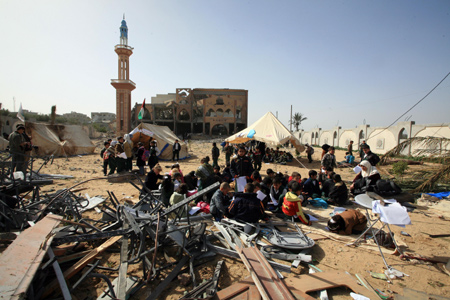 Palestinian pupils attend a class outside their destroyed school in Rafah, southern Gaza Strip, on January 25, 2009.