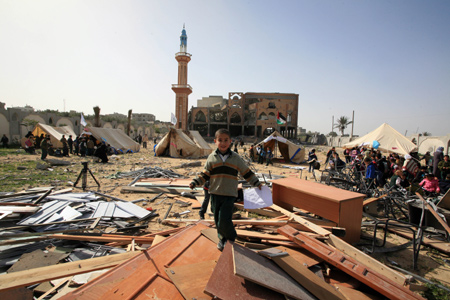 Palestinian pupils attend a class outside their destroyed school in Rafah, southern Gaza Strip, on January 25, 2009.