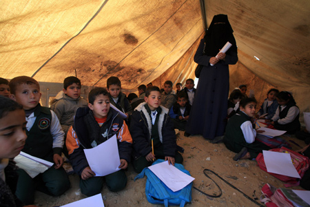 Palestinian pupils attend a class outside their destroyed school in Rafah, southern Gaza Strip, on January 25, 2009.