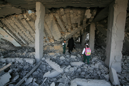 A teacher and some students inspect the building of a school destroyed by Israel in Rafah, southern Gaza Strip, on January 25, 2009.