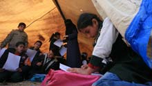 Palestinian pupils attend a class outside their destroyed school in Rafah, southern Gaza Strip, on January 25, 2009.