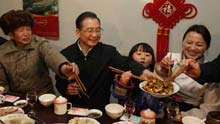 Chinese Premier Wen Jiabao (2nd L) shares the twice-cooked pork slices he cooked with family members of local resident Wu Zhiyuan, in Yingxiu Township of Wenchuan County, southwest China's Sichuan Province, on January 25, 2009. Wen Jiabao came to the quake-hit counties of Beichuan, Deyang and Wenchuan in Sichuan Province on Janury 24 and 25, celebrating the Spring Festival with local residents.