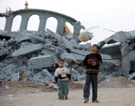  Two Palestinian boys play with a ball by a destroyed mosque in the southern Gaza Strip, Jan. 26, 2009. (Xinhua/ 