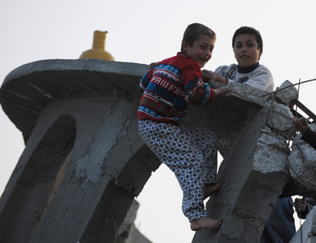 Two Palestinian boys play on the debris of a destroyed mosque in the southern Gaza Strip, on January 26, 2009. [Xinhua]