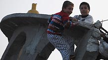 Two Palestinian boys play on the debris of a destroyed mosque in the southern Gaza Strip, on January 26, 2009. [Xinhua]