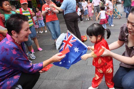 Sydney Mayor Clover Moore (L) presents gifts to a kid in Chinese Street to share the happiness of Chinese Lunar New Year in Sydney, Australia, on January 26, 2009.