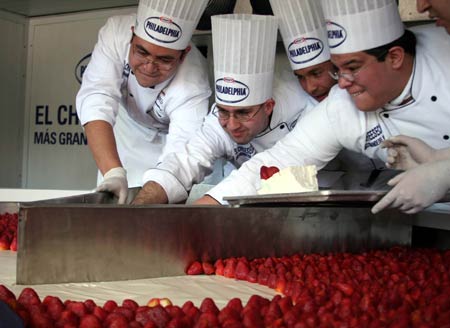 Chefs cut a giant cheesecake that broke Guinness World Record for the biggest cheesecake of the world in Mexico City, capital of Mexico, on January 25, 2009. The cheese cake, with 2.5 meters in diameter, 55 centimeters in height and 2 tons in weight, was made by 55 chefs and 5 student chefs and cost 800 kilograms of cheese.