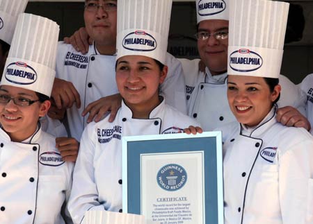 Student chefs display a certificate of Guinness World Record for the biggest cheesecake of the world in Mexico City, capital of Mexico, on January 25, 2009. The cheese cake, with 2.5 meters in diameter, 55 centimeters in height and 2 tons in weight, was made by 55 chefs and 5 student chefs and cost 800 kilograms of cheese.