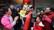 Chinese Premier Wen Jiabao (C) holds a girl in arms during his visit to the residents in Yingxiu Township of Wenchuan County, southwest China's Sichuan Province, on January 25, 2009. Wen Jiabao came to the quake-hit counties of Beichuan, Deyang and Wenchuan in Sichuan Province on January 24 and 25, celebrating the Spring Festival with local residents.