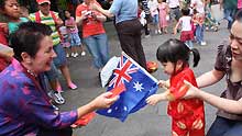 Sydney Mayor Clover Moore (L) presents gifts to a kid in Chinese Street to share the happiness of Chinese Lunar New Year in Sydney, Australia, on January 26, 2009.