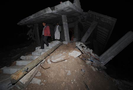 A relative of Mahamad Abd Raabo leaves the houses of Abd Raabo in Jibaliya, northern Gaza Strip, on January 27, 2009. The two-floor building which costed 18-year hard work of Abd Raabo was damaged during Israeli military attacks. Abd Raabo and his wife are unwilling to leave and still living in it. [Xinhua]