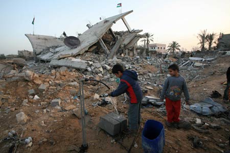 A Palestinian child washes articles in the rubbles in al Moghraqa area in the central Gaza Strip, on January 29, 2009.