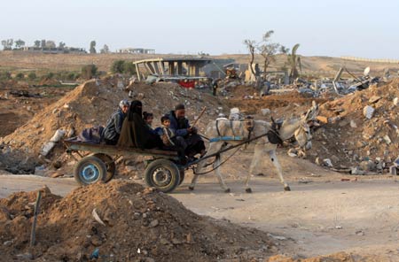 Palestinians sit on a carriage in the rubbles in al Moghraqa area in the central Gaza Strip, on January 29, 2009.