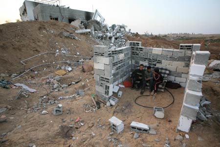 Palestinians sit in the rubbles in al Moghraqa area in the central Gaza Strip, on January 29, 2009.