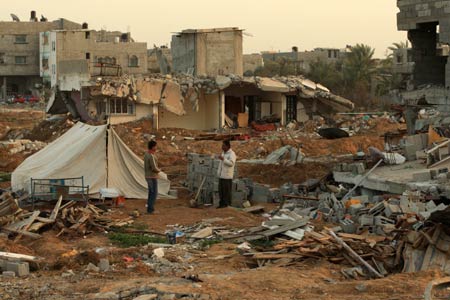 Palestinians stand in the rubbles in al Moghraqa area in the central Gaza Strip, on January 29, 2009.