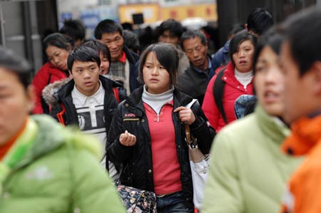 Migrant workers walk out of Hangzhou Railway Station in Hangzhou, east China's Zhejiang Province, on January 30, 2009. 