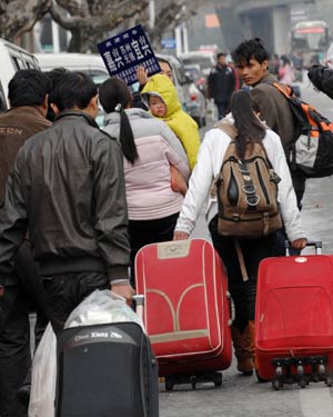 Migrant workers walk out of Hangzhou Railway Station in Hangzhou, east China's Zhejiang Province, on January 30, 2009.