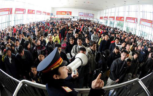 A railway staffer reminds the waiting crowds at the entry to keep order at the Changsha Railway Station in central Hunan Province on Friday, on January 30, 2009.