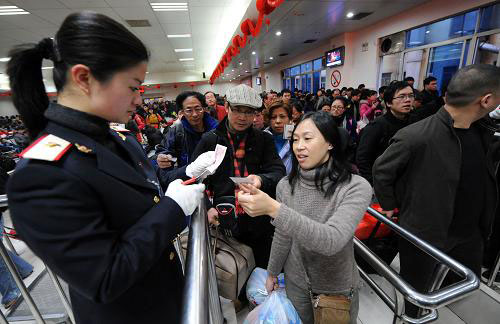 Passengers pass the entry at the Nanchang Railway Station in the eastern Jiangxi Province on Friday, on January 30, 2009.