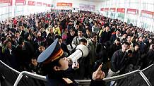 A railway staffer reminds the waiting crowds at the entry to keep order at the Changsha Railway Station in central Hunan Province on Friday, on January 30, 2009.